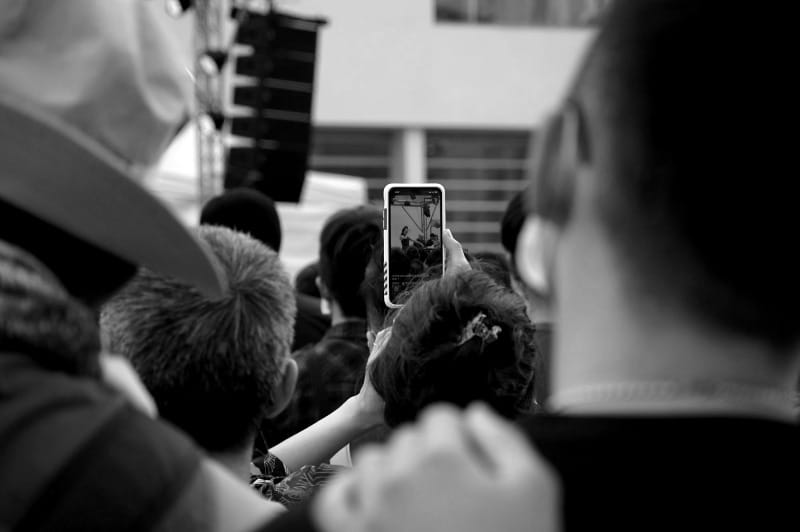 a crowd of people standing around each other
