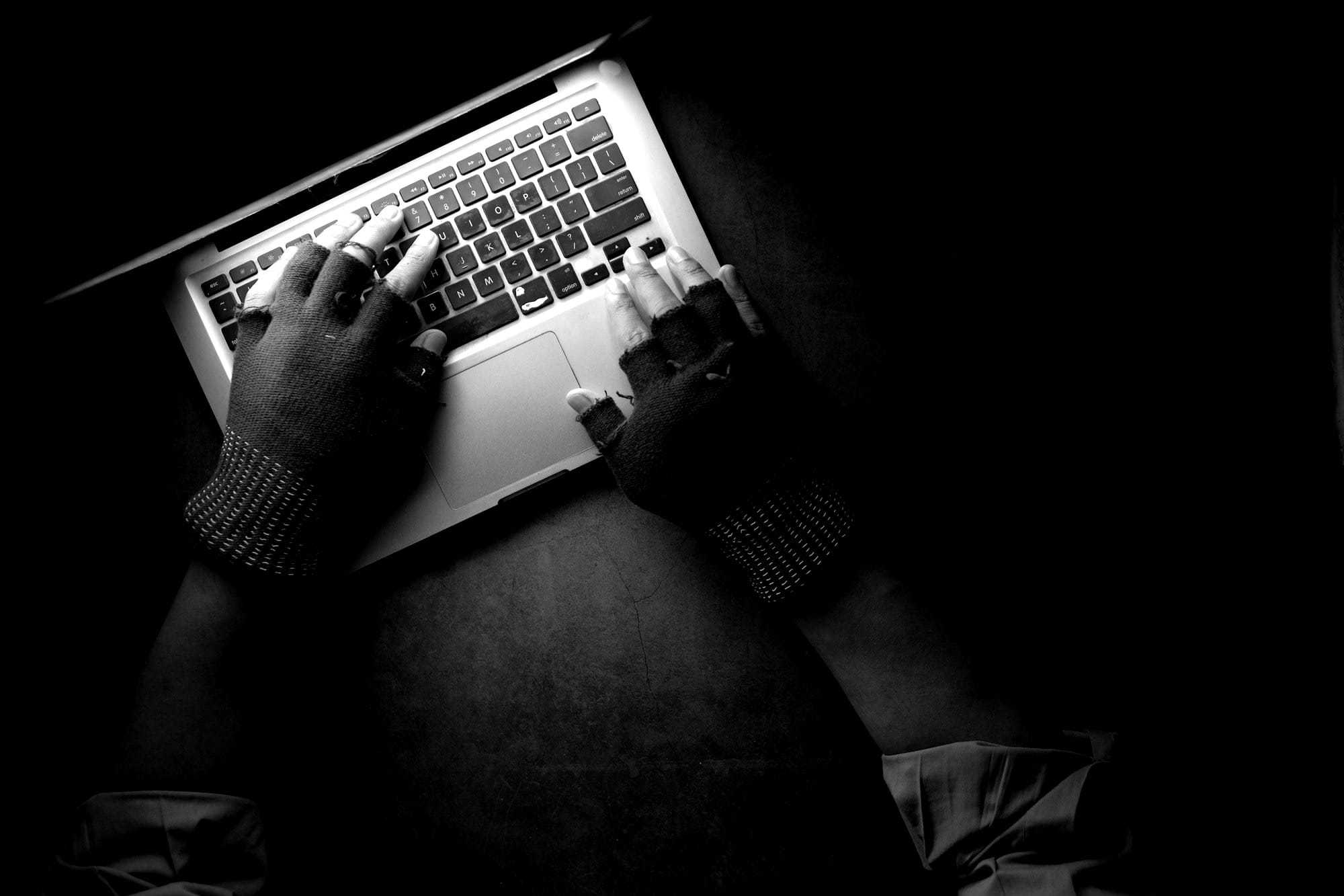 person in black long sleeve shirt using macbook pro