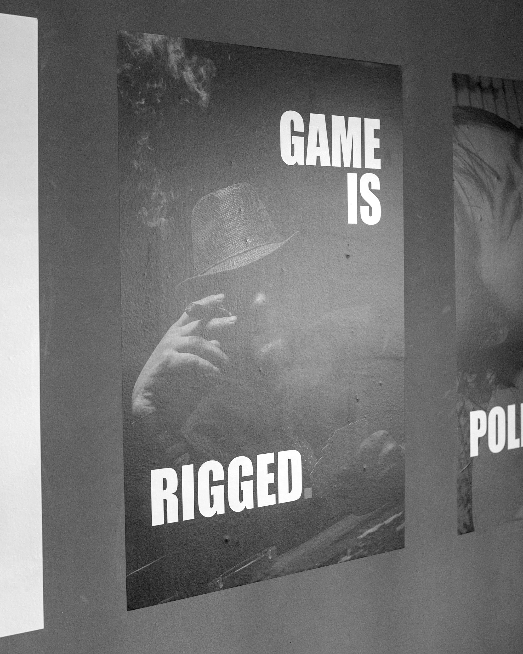 Poster with text 'game is rigged' and man.